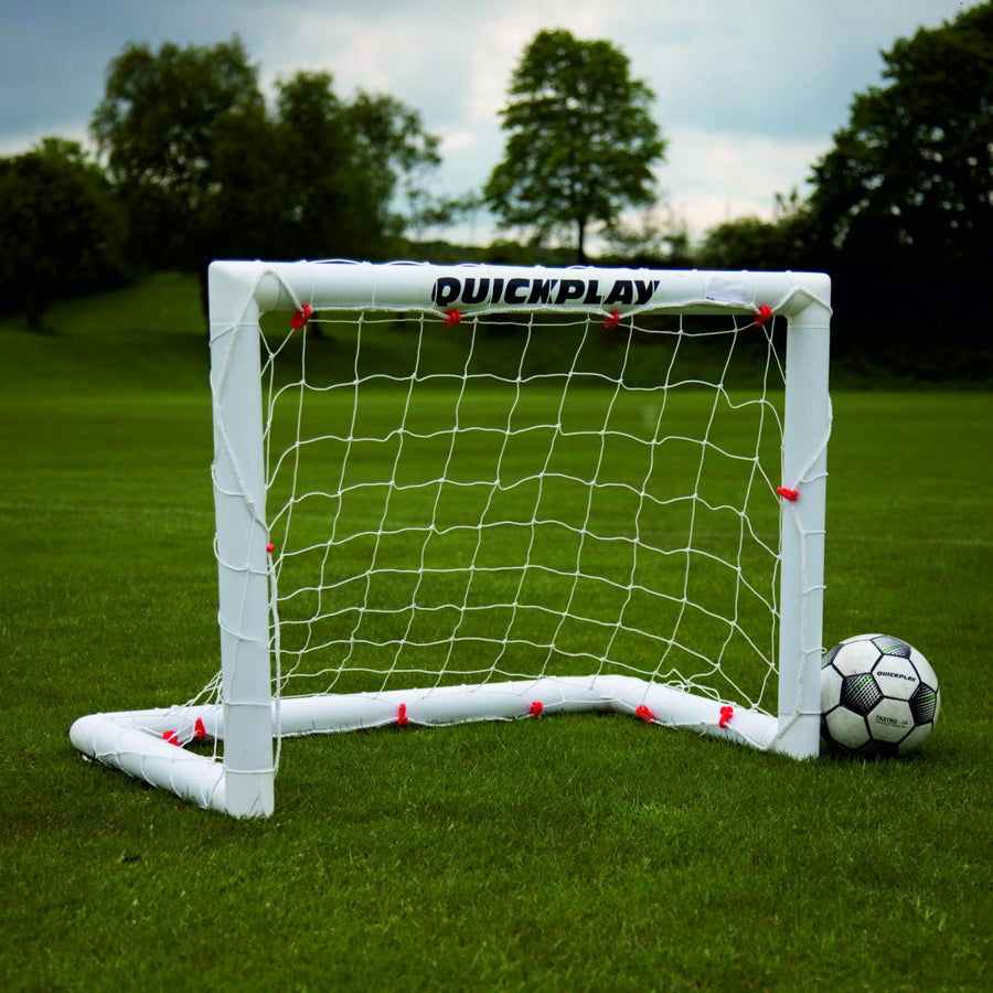 Q-FOLD Mini-Fußballtor 90 x 75 cm mit weißem Rahmen und Netz auf Rasen, daneben ein Fußball.