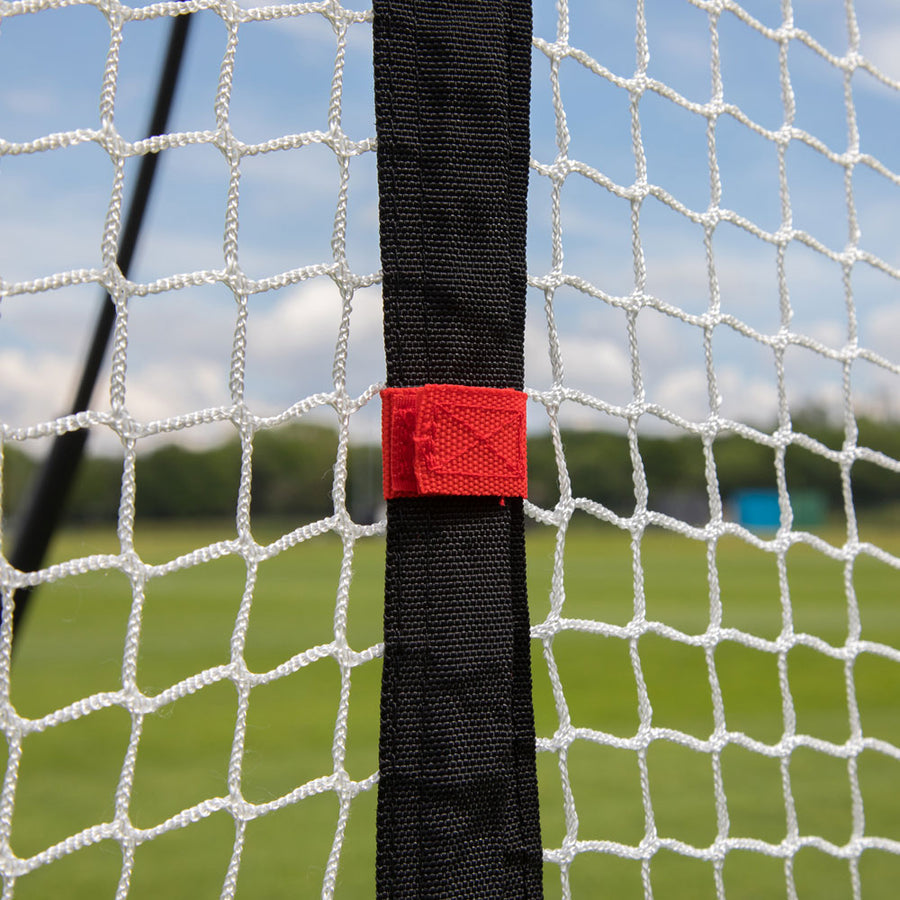 MEGA NET XL in Nahaufnahme: schwarzer Seitengurt mit roter Lasche vor dem weißen Netz.