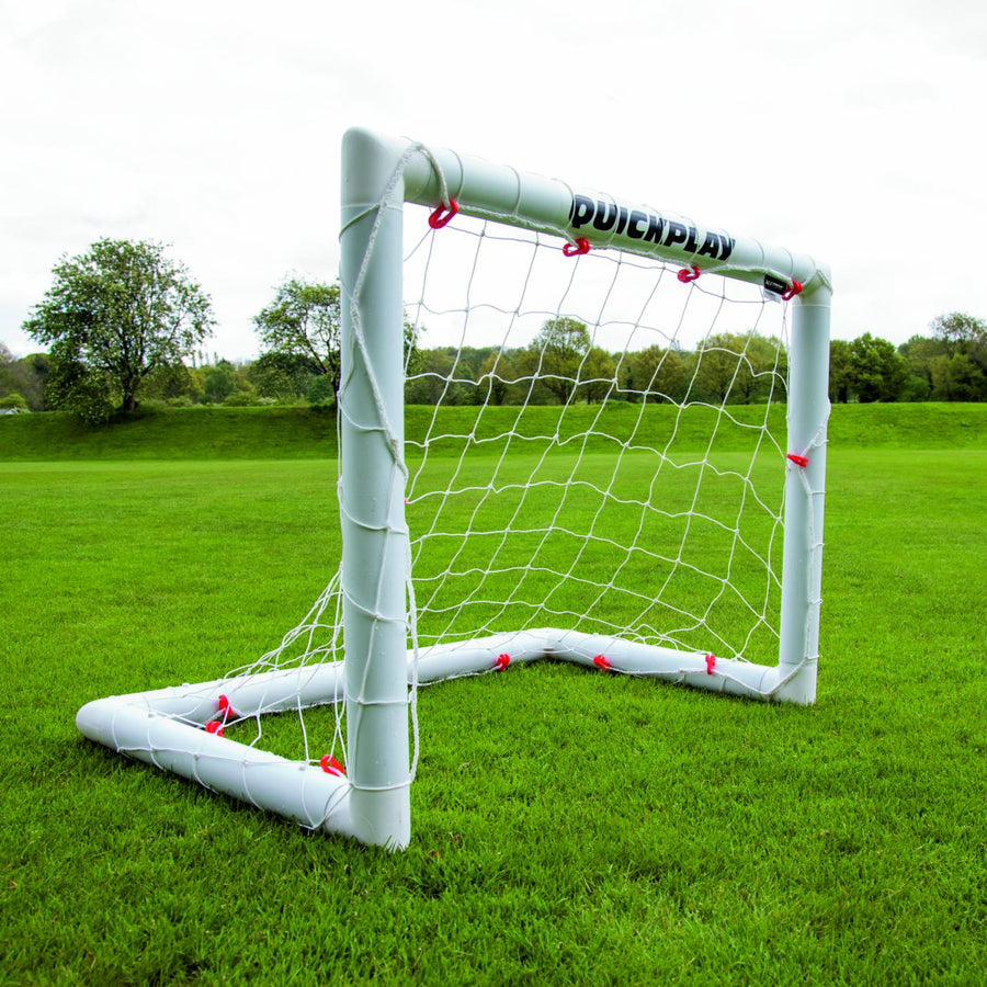 Q-FOLD Mini-Fußballtor 90 x 75 cm auf einem Rasenfeld, schräg von vorn gesehen.