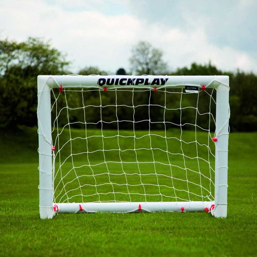 Q-FOLD Mini-Fußballtor 90 x 75 cm von vorn auf Rasen, mit QUICKPLAY auf der weißen Querlatte.