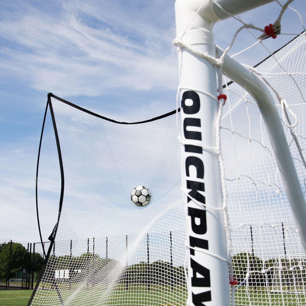 MEGA NET XL fängt einen Fußball hinter einem Tor, im Vordergrund ein weißer QUICKPLAY Torpfosten.