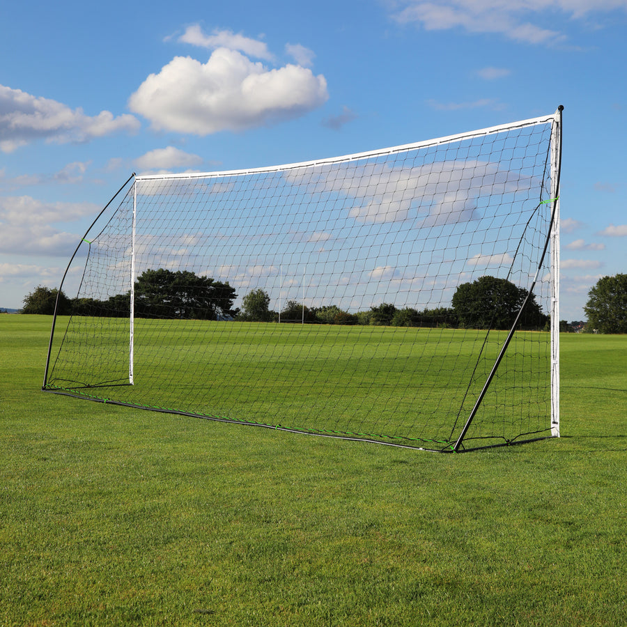 KICKSTER Tragbares Fußballtor 500 x 200 cm seitlich aus niedriger Perspektive auf Rasen, mit schwarzem hinterem Rahmen und Netz.