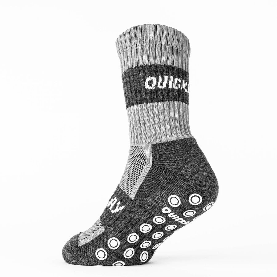 Einzelne QUICKPLAY Grip-Socke von der Seite, hellgrauer Bund mit QUICKPLAY Band, dunkelgrauer Fußteil und Grip-Noppen.