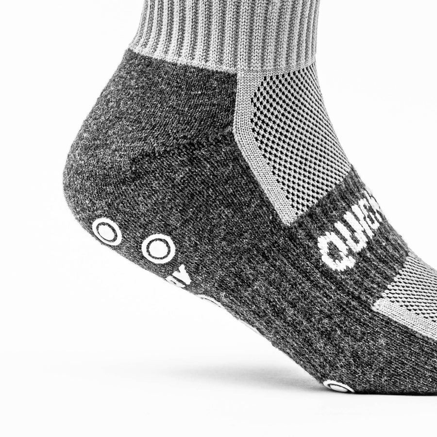 Ferse und Knöchel einer QUICKPLAY Grip-Socke in Nahaufnahme, mit dunkelgrauem gepolstertem Fußteil und hellgrauem Mesh-Einsatz.