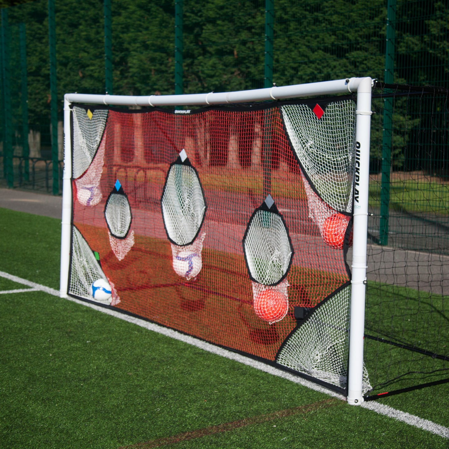 TARGET Torwand-Netz 370 x 180 cm an einem weißen Tor, mit Bällen in mehreren seiner Fangtaschen.