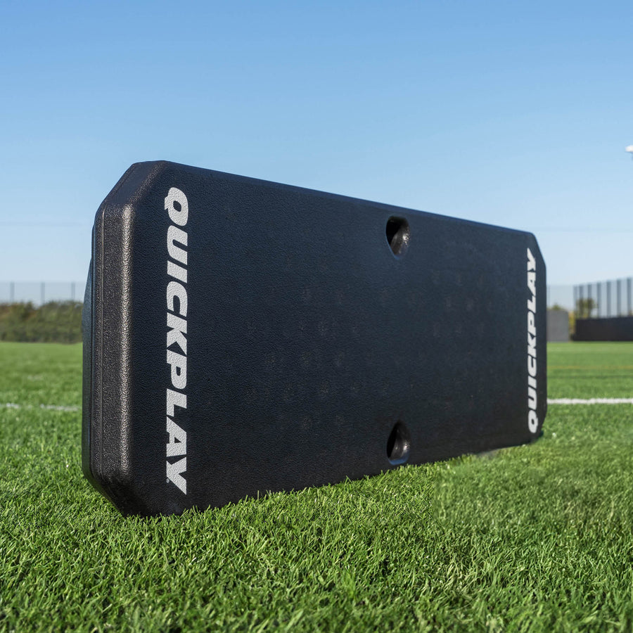 REPLAY Boombox Fußball-Rebound-Board, schwarz mit weißen QUICKPLAY Logos, auf Kunstrasen stehend.