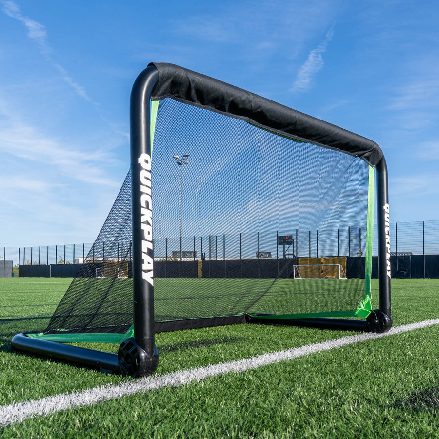 RHINO Alu-Fußballtor 120 x 75 cm mit dickem schwarzem Rahmen und schwarzem Netz, auf der Linie eines Kunstrasenplatzes.