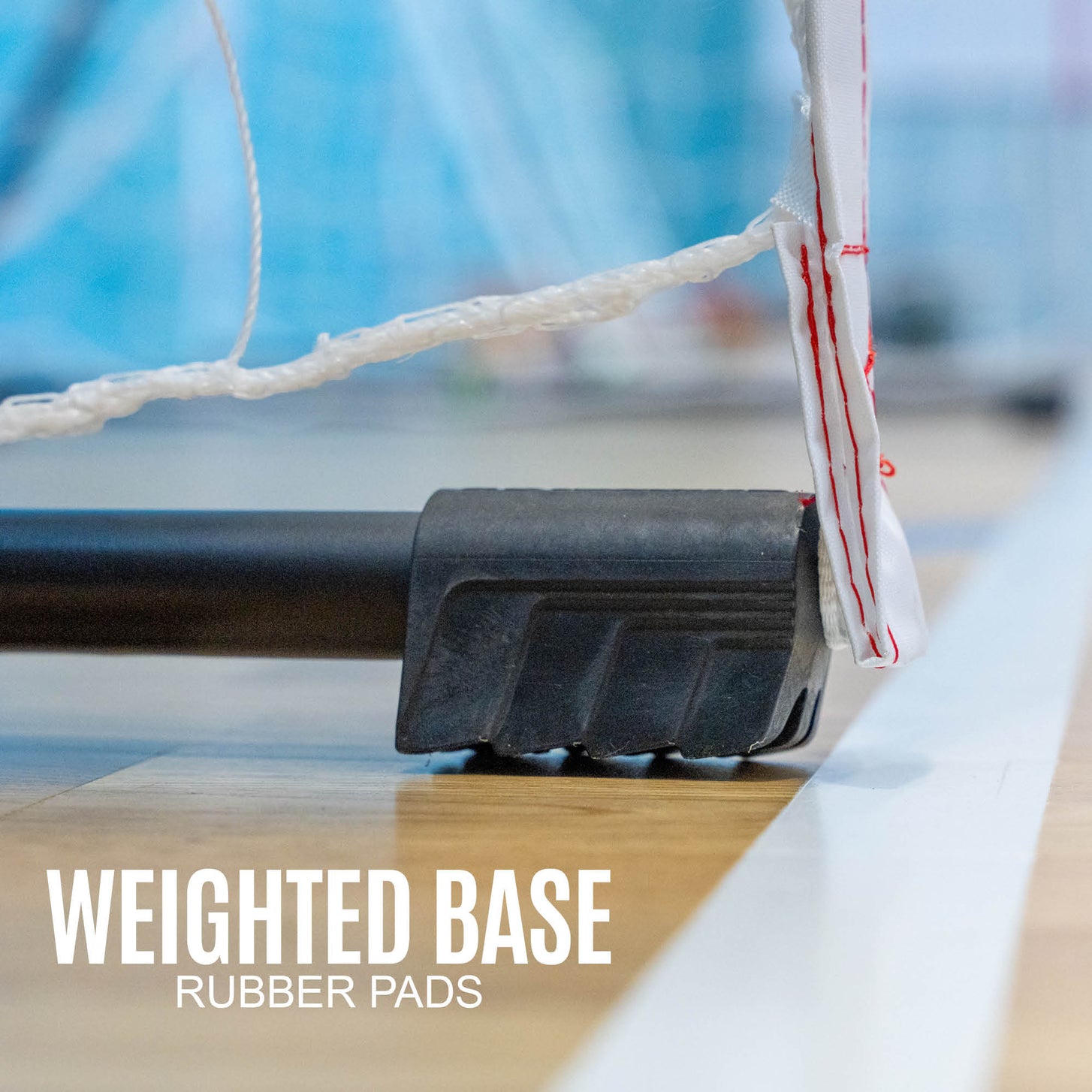 Tragbares Jugend-Handballtor 240 x 170 cm, Fuß in Nahaufnahme auf einem Hallenboden, mit dem Text „weighted base, rubber pads“.