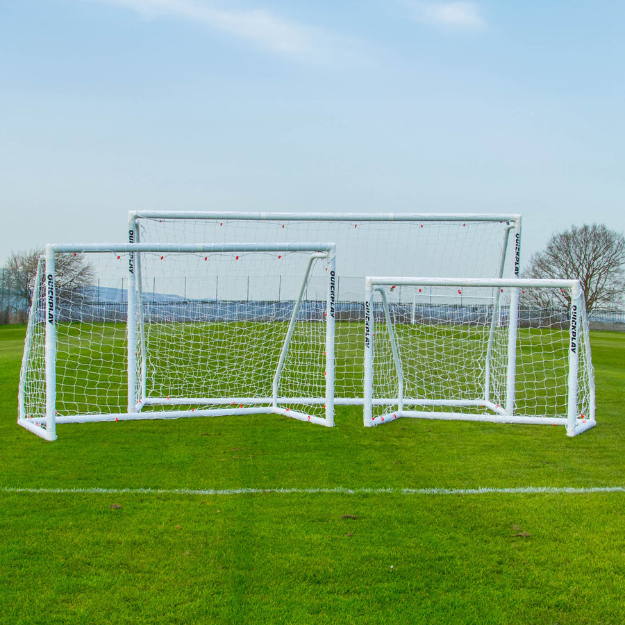 Drei weiße Q-FOLD Match Tore in verschiedenen Größen nebeneinander auf einem Rasenplatz.