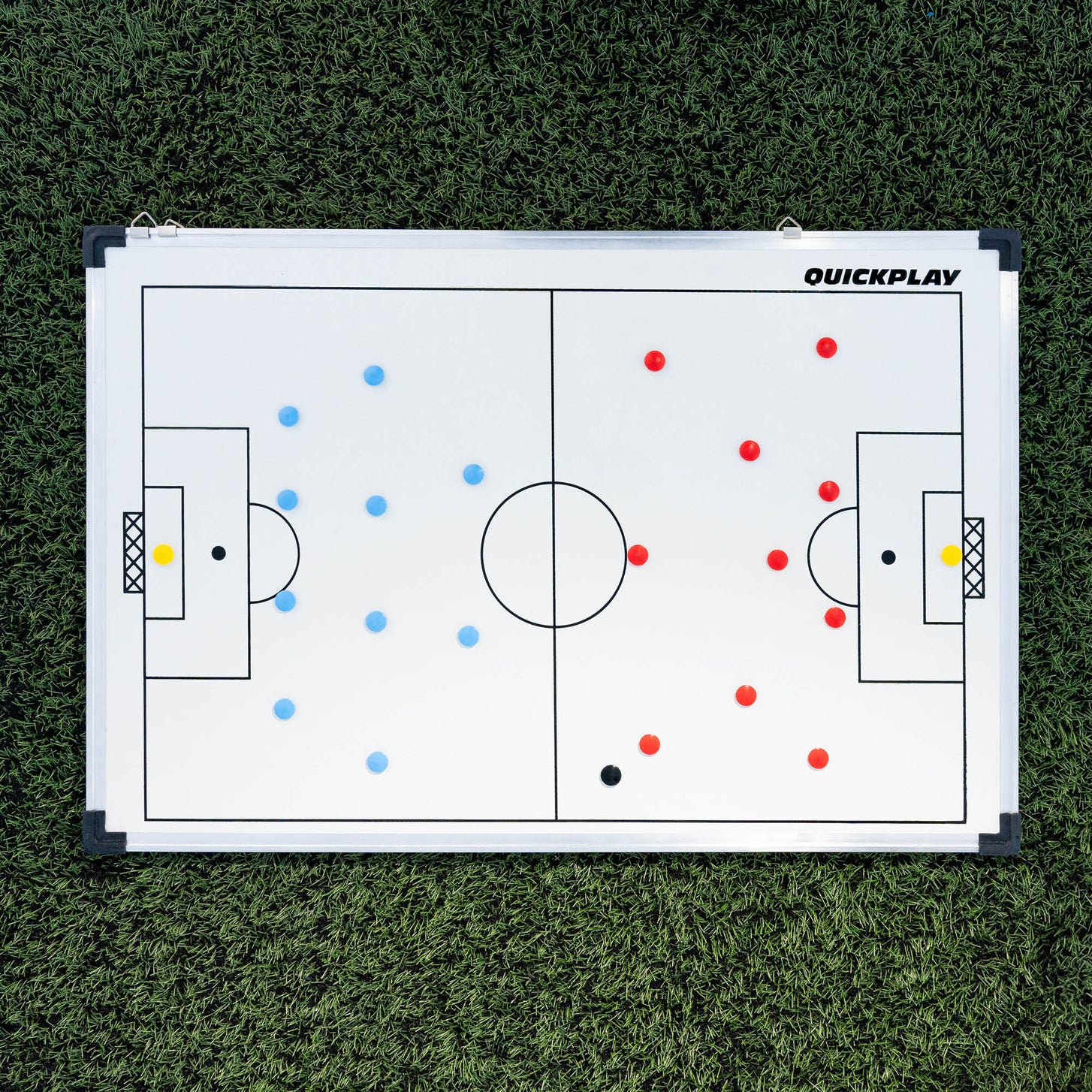 Magnetische Fußball-Taktiktafel 60 x 90 cm flach auf Kunstrasen, mit roten und blauen Magnet-Teams aufgestellt.