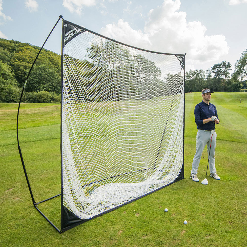 QUICK-HIT Golfnetz 240 x 240 cm auf einem Golfplatz aufgebaut, daneben ein Golfer mit Schläger und Bälle auf dem Rasen.